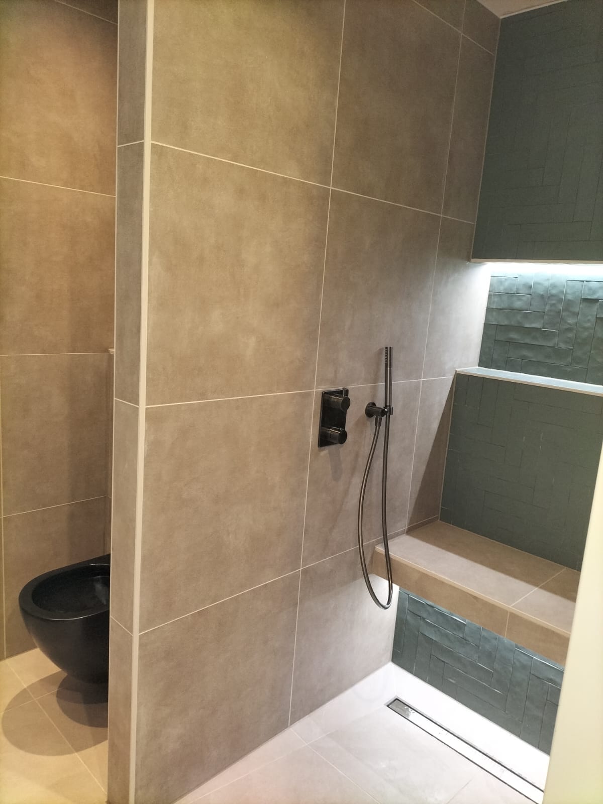 Een betegelde zitbank in de douche