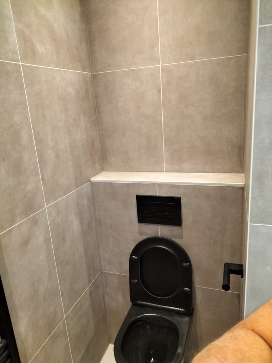 Zwart toilet in de beige wand